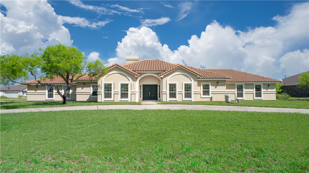 a view of house with garden and trees in the background