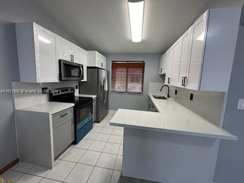 a kitchen with a sink a counter top space cabinets and stainless steel appliances