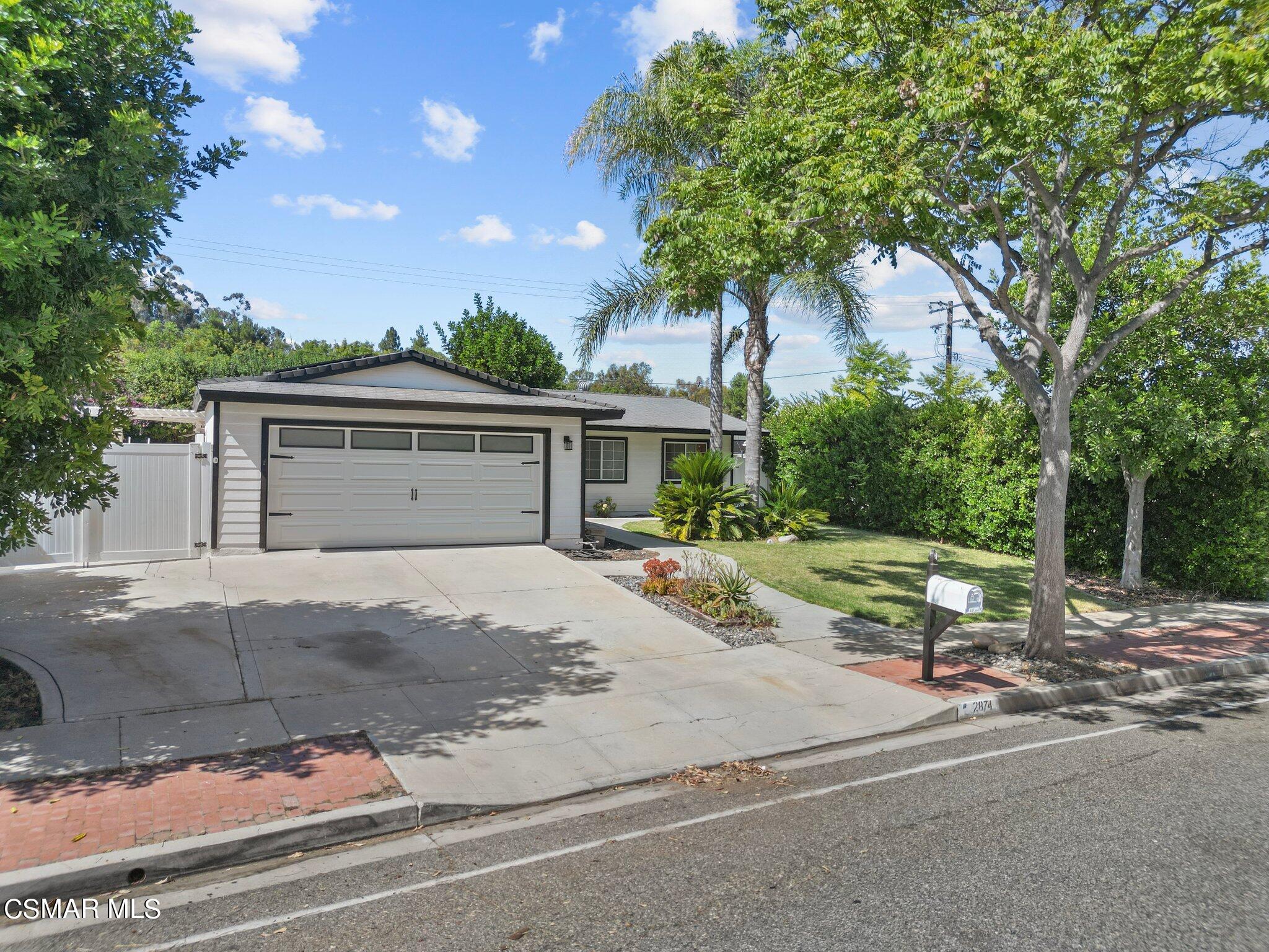 front view of a house with a yard and potted plants