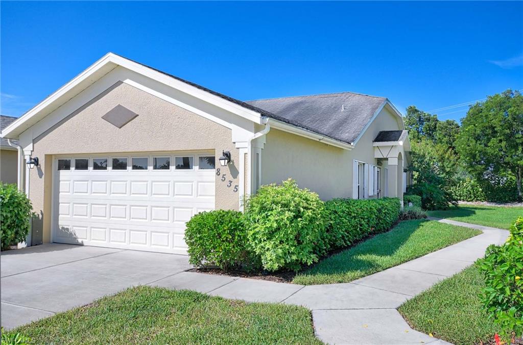 View of front of property with a front yard and a garage