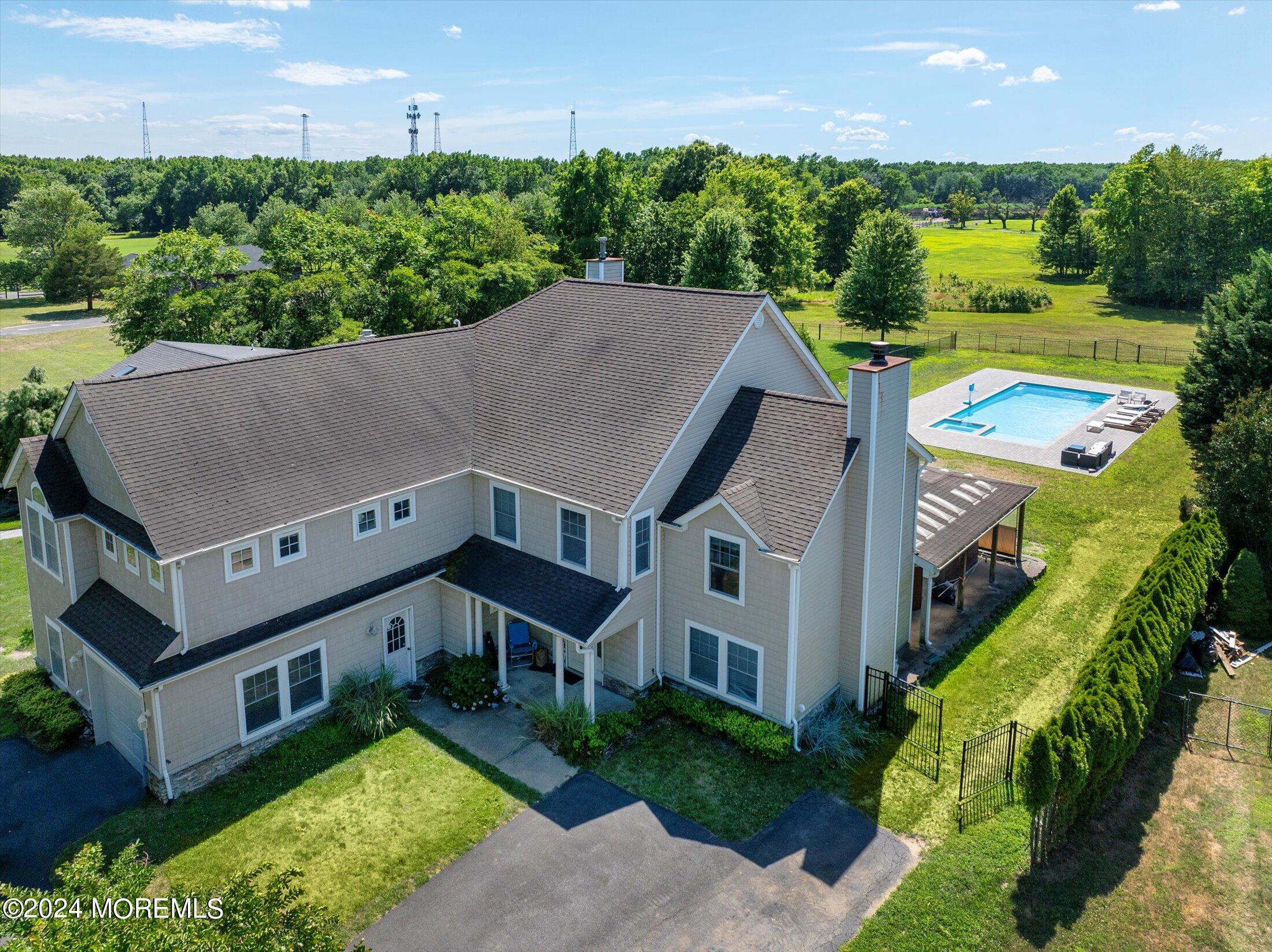 a aerial view of a house with swimming pool and large trees