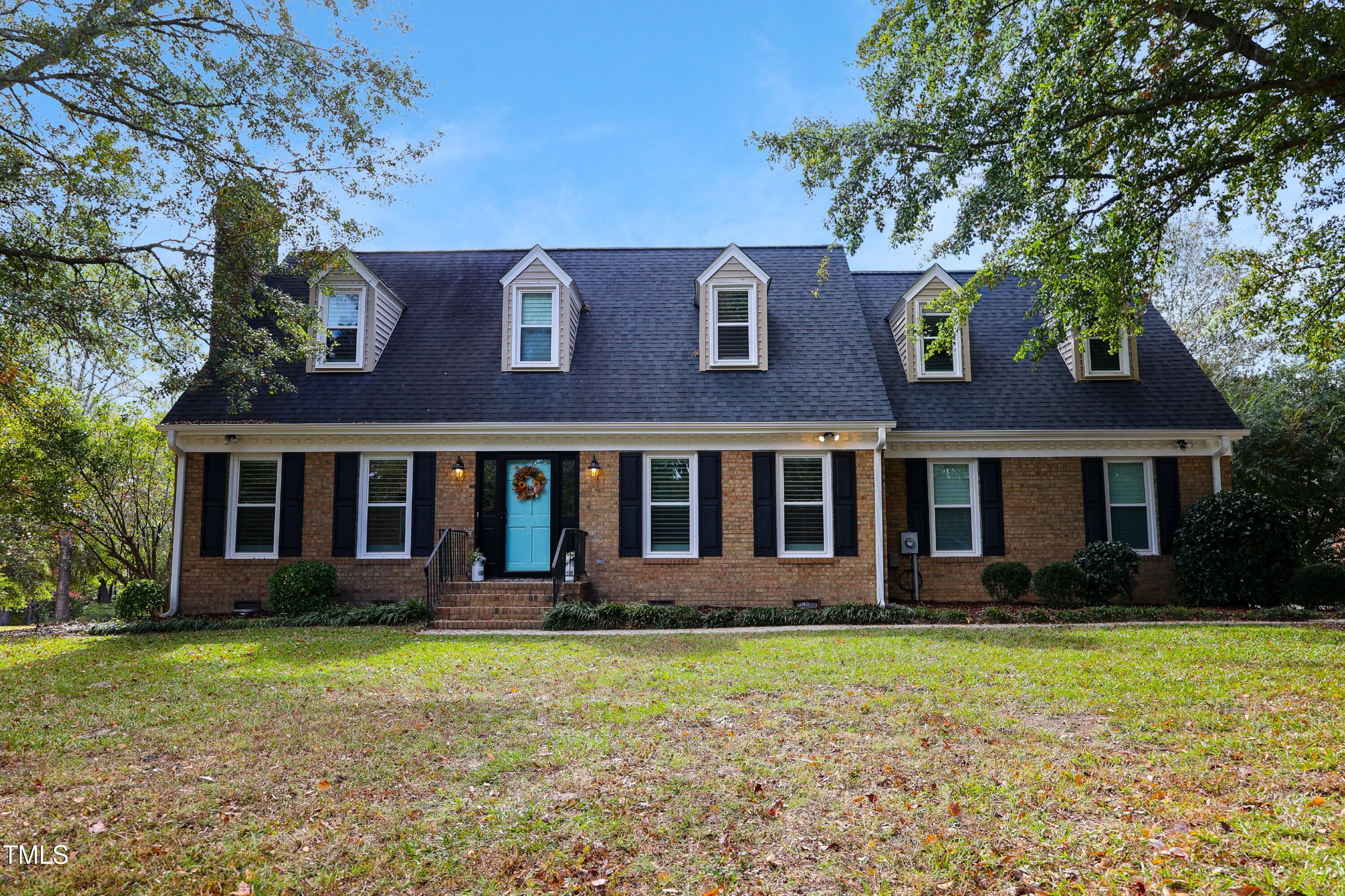 front view of a brick house with a yard