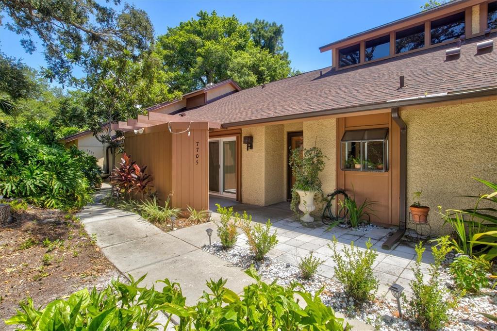 a front view of a house with a yard outdoor seating and a tree