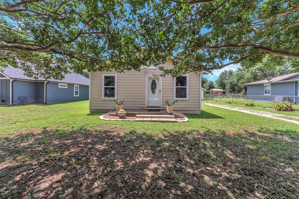 a view of a house with backyard and a tree