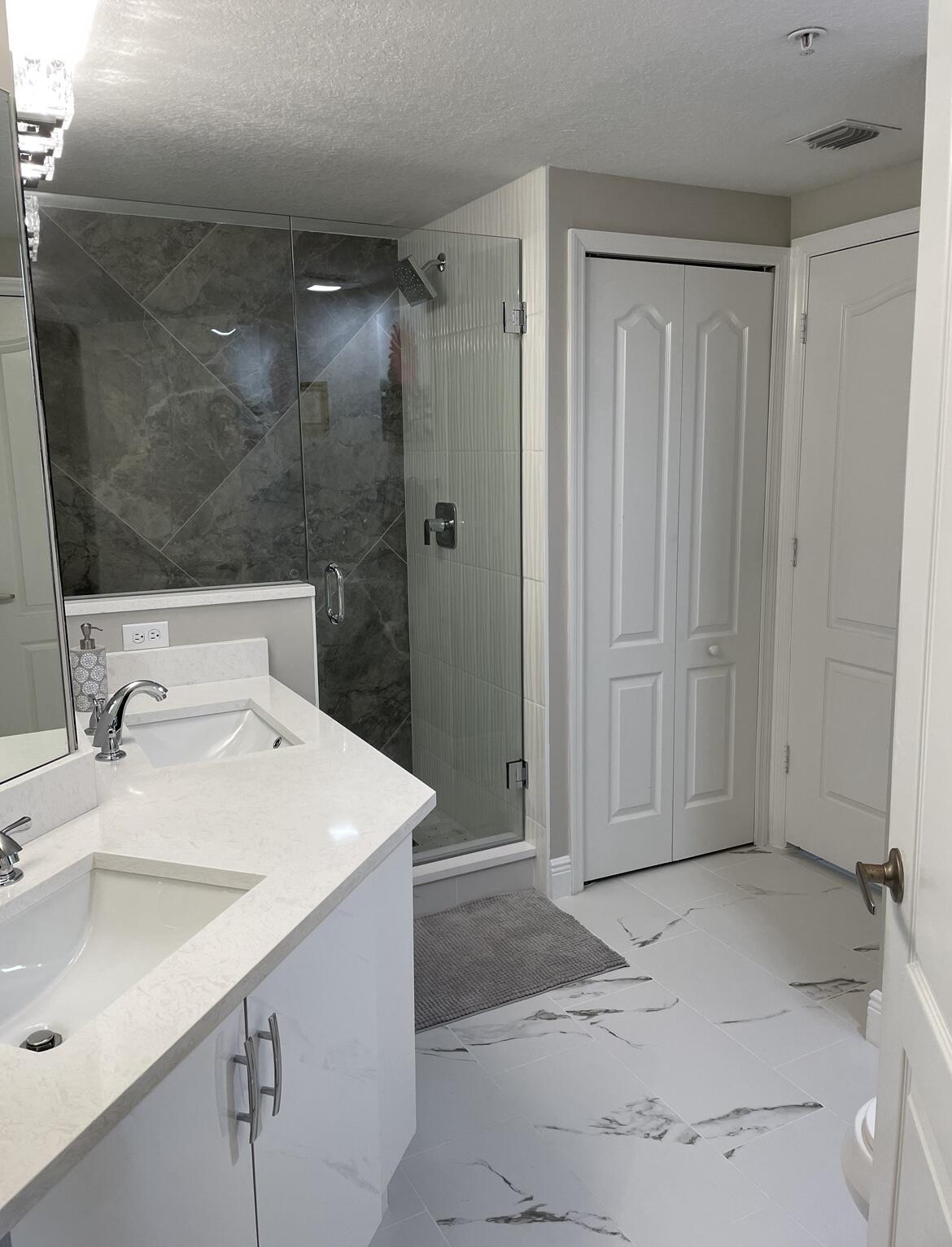 a bathroom with a sink shower and a mirror