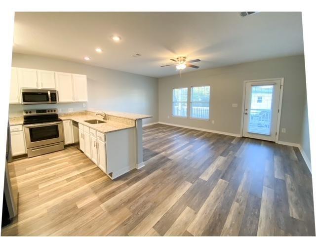 a view of a kitchen with a sink cabinets and wooden floor