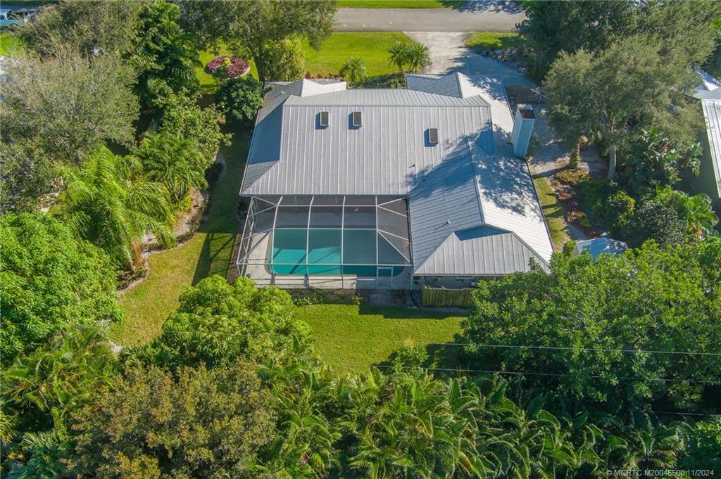 an aerial view of a house with swimming pool and garden