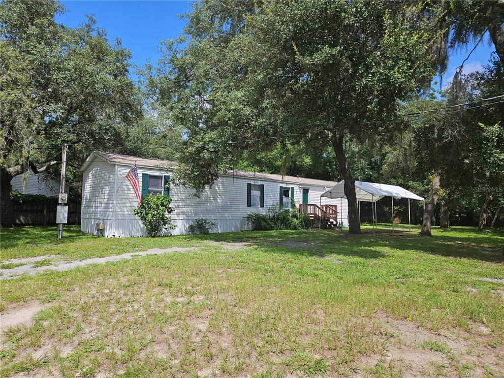 a front view of a house with a yard and trees