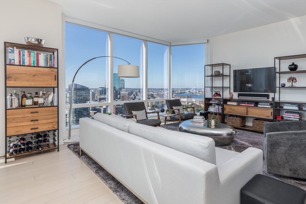 a living room with furniture a large window and a flat screen tv