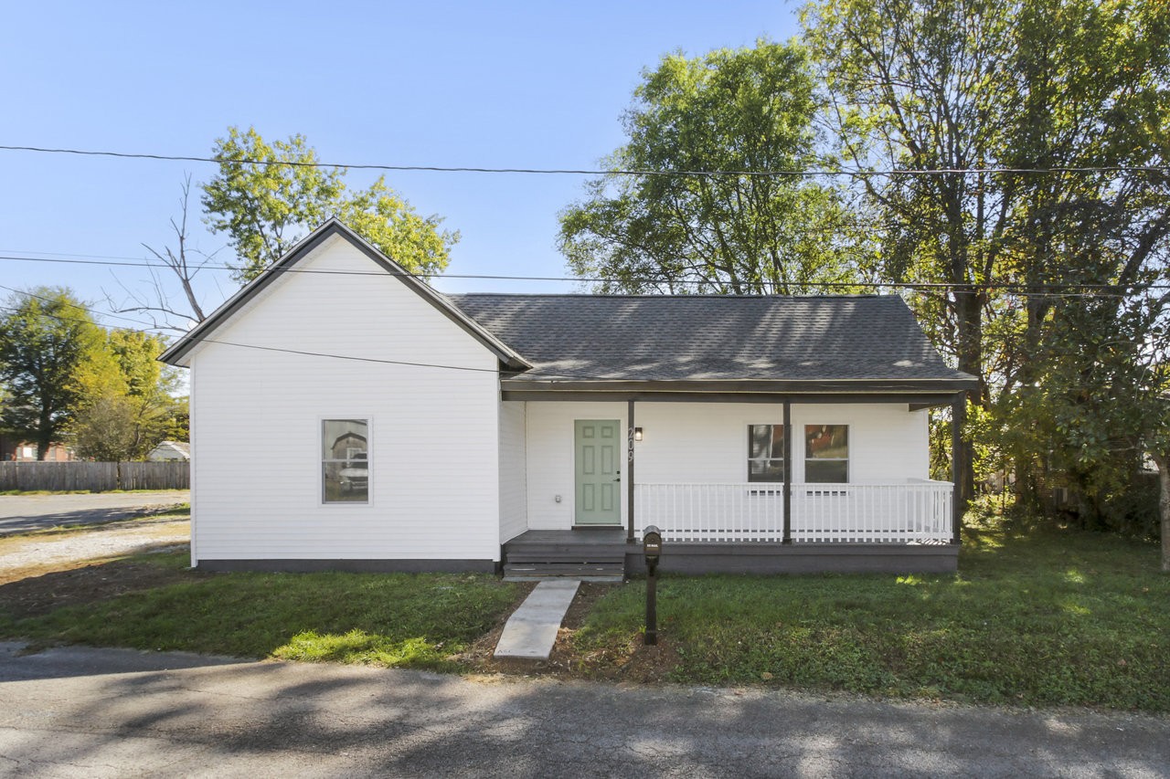 a view of a white house next to a yard and a yard