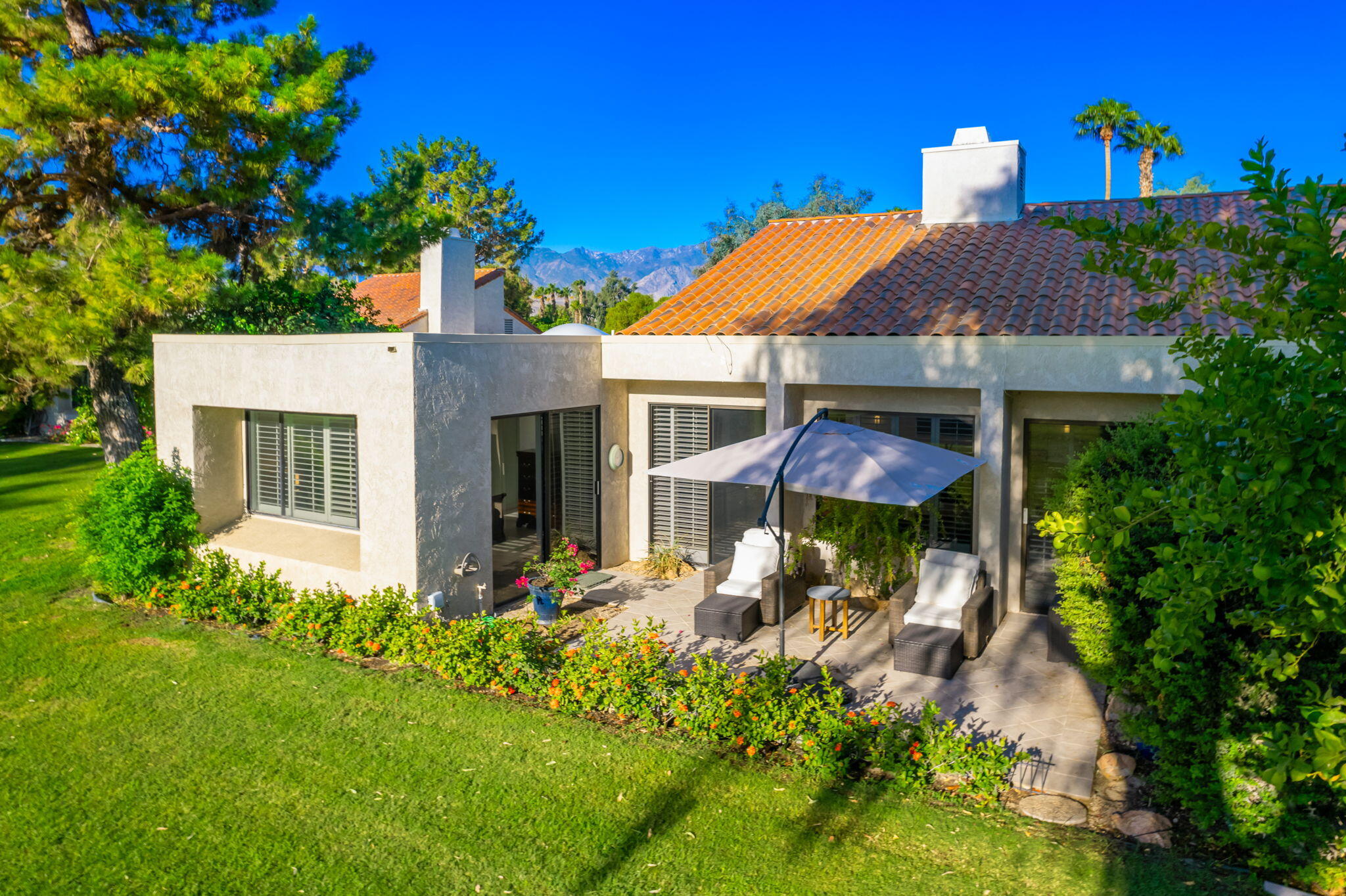 a front view of a house with a yard and fountain in middle