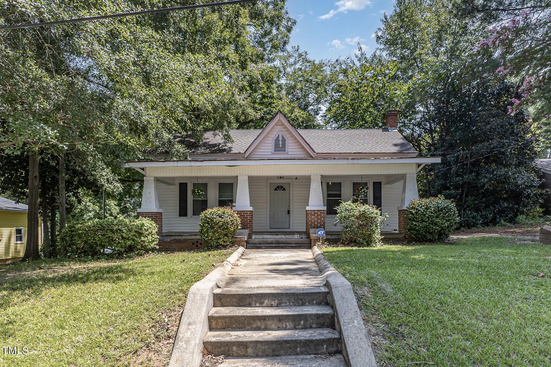 a front view of a house with garden and porch