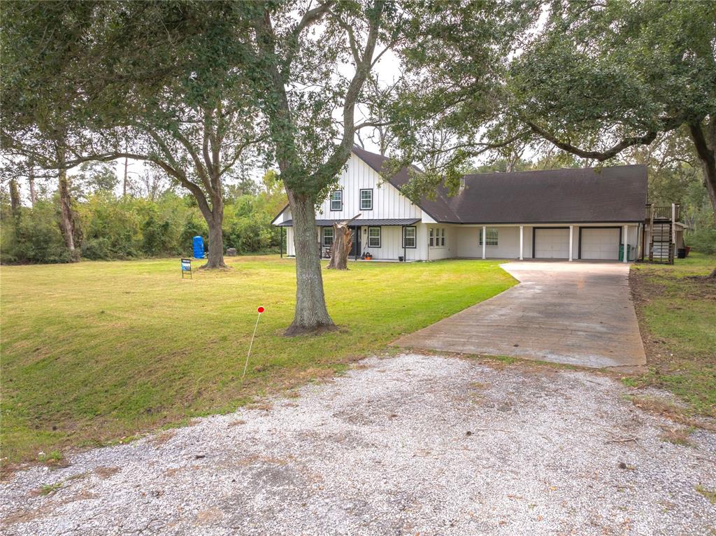 a view of a house with a yard and large tree