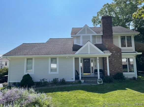 a front view of a house with a yard and potted plants