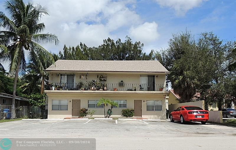 a front view of a house with a garden and trees