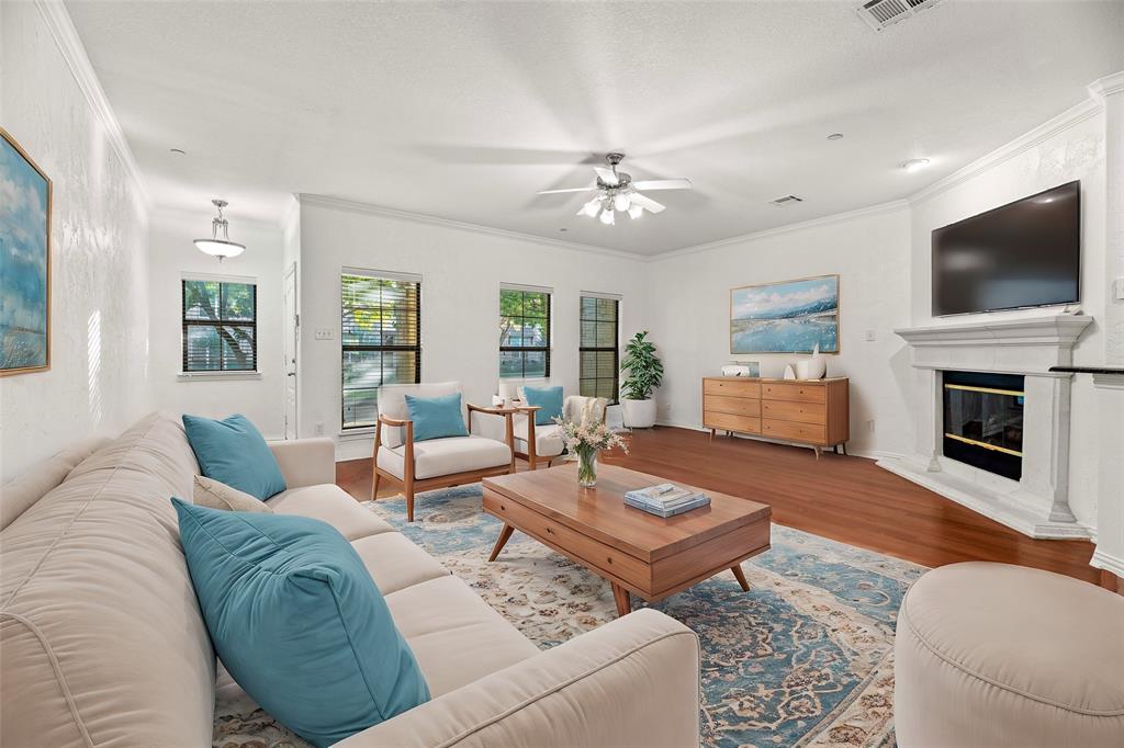 a living room with furniture a flat screen tv and a fireplace