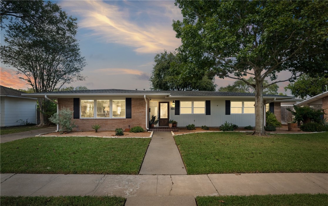 a front view of a house with a yard and trees