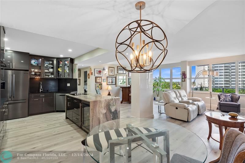 a living room with furniture a large window and stainless steel appliances