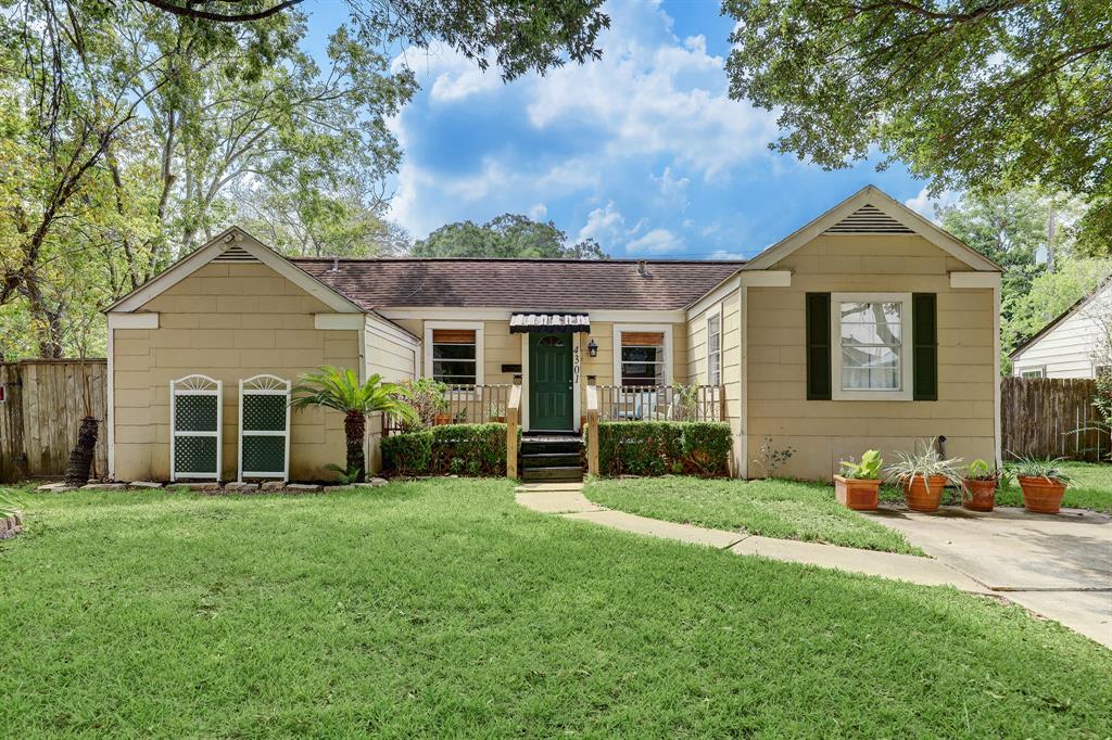 a front view of a house with a yard and trees