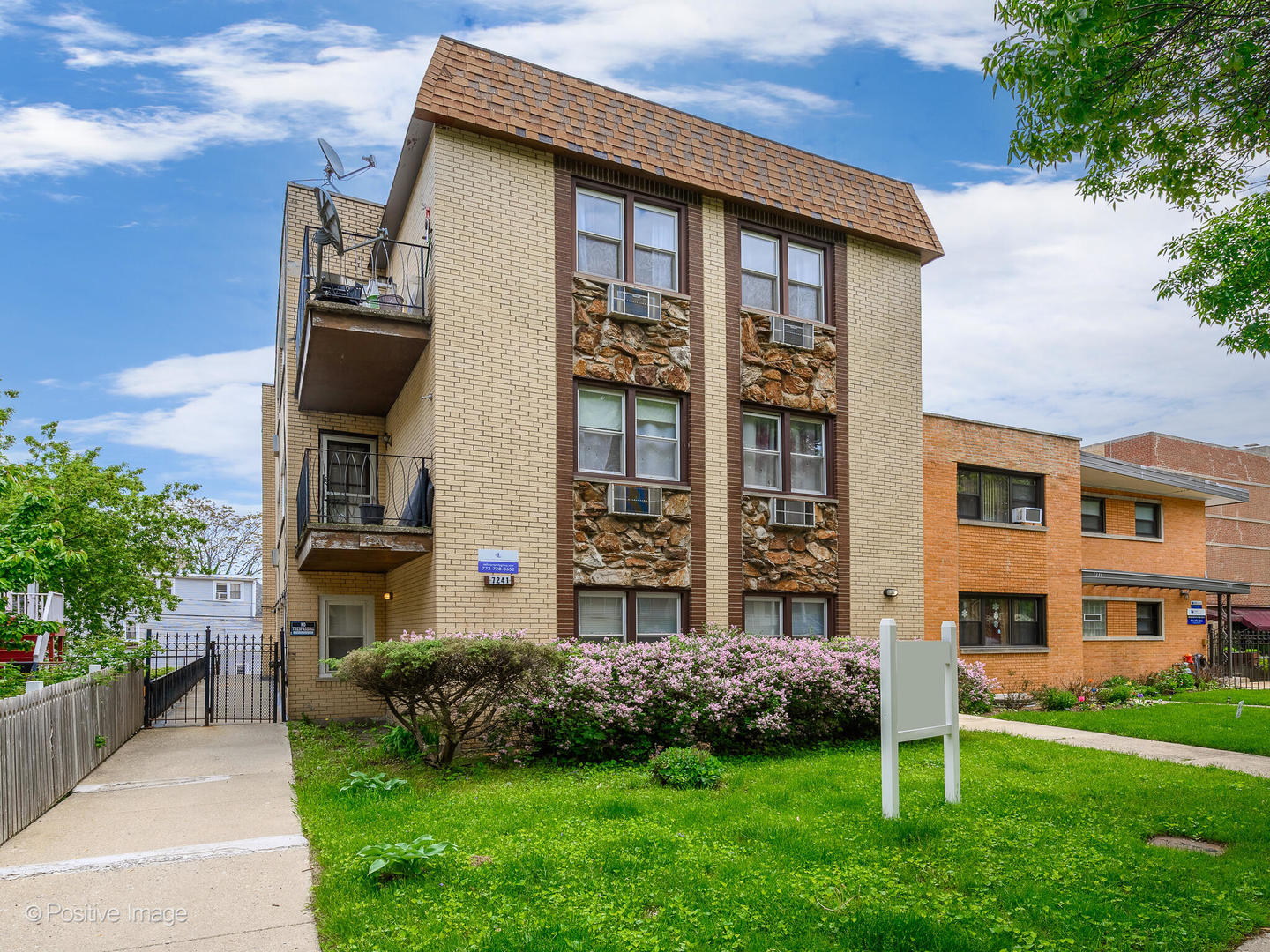 a front view of a residential apartment building with a yard