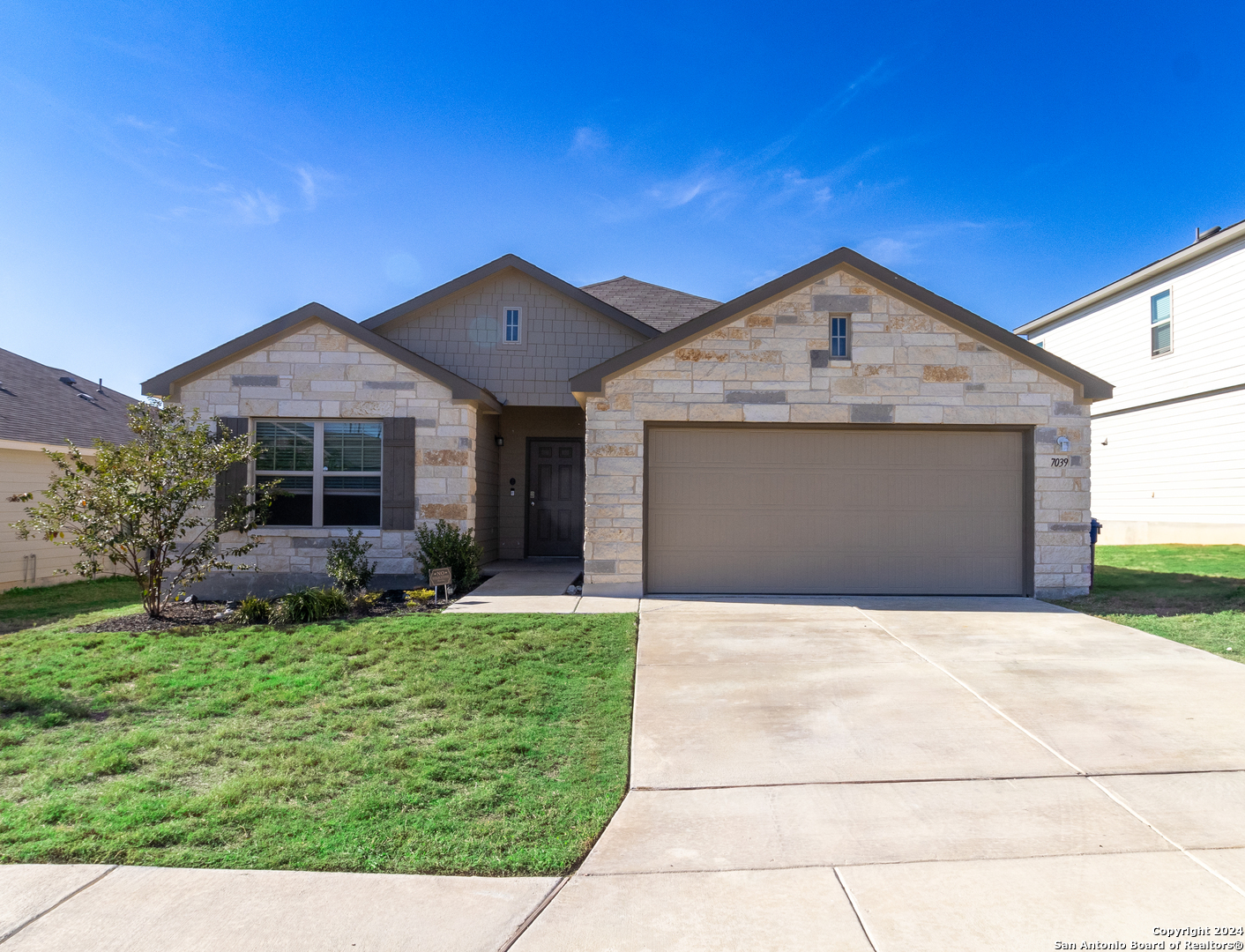 a front view of a house with a yard and garage