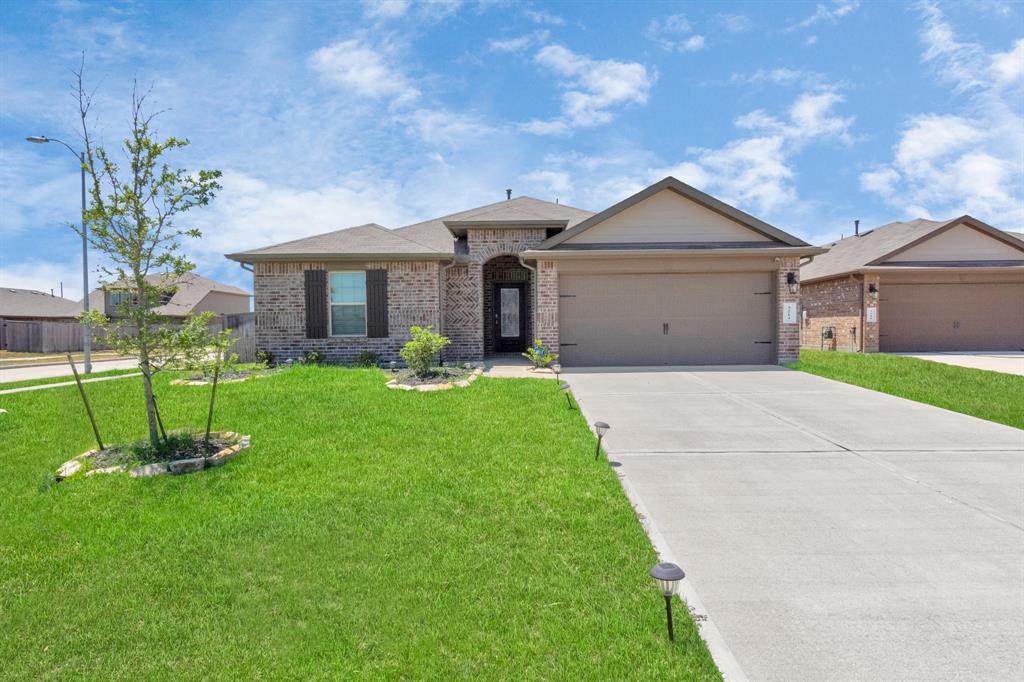 a front view of a house with a yard and a tree