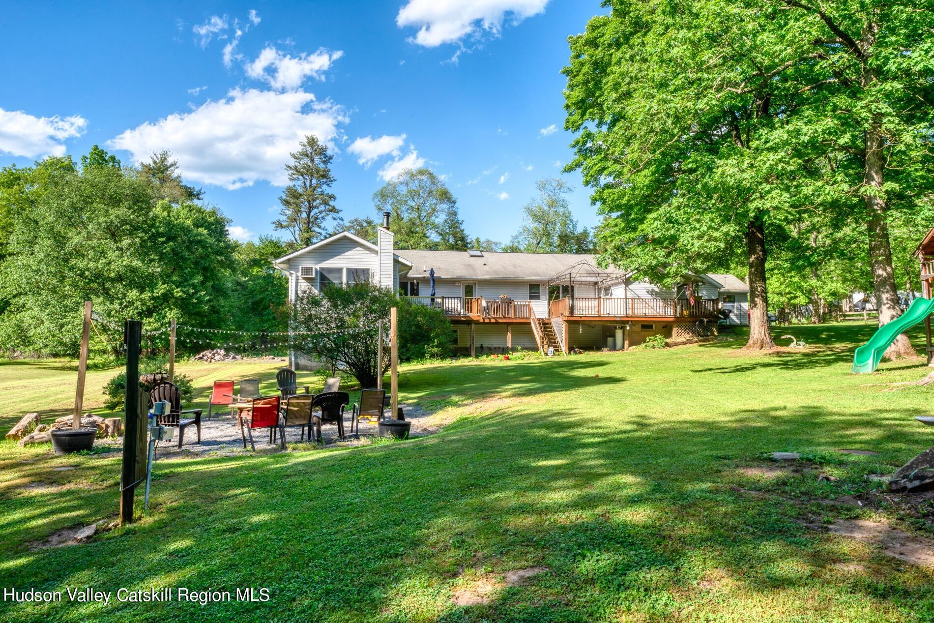 a view of a house with a big yard and large trees