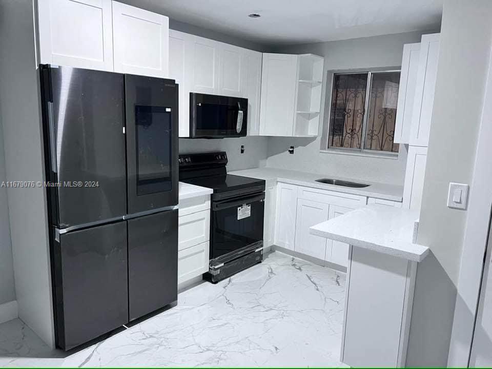 a kitchen with a refrigerator sink and microwave