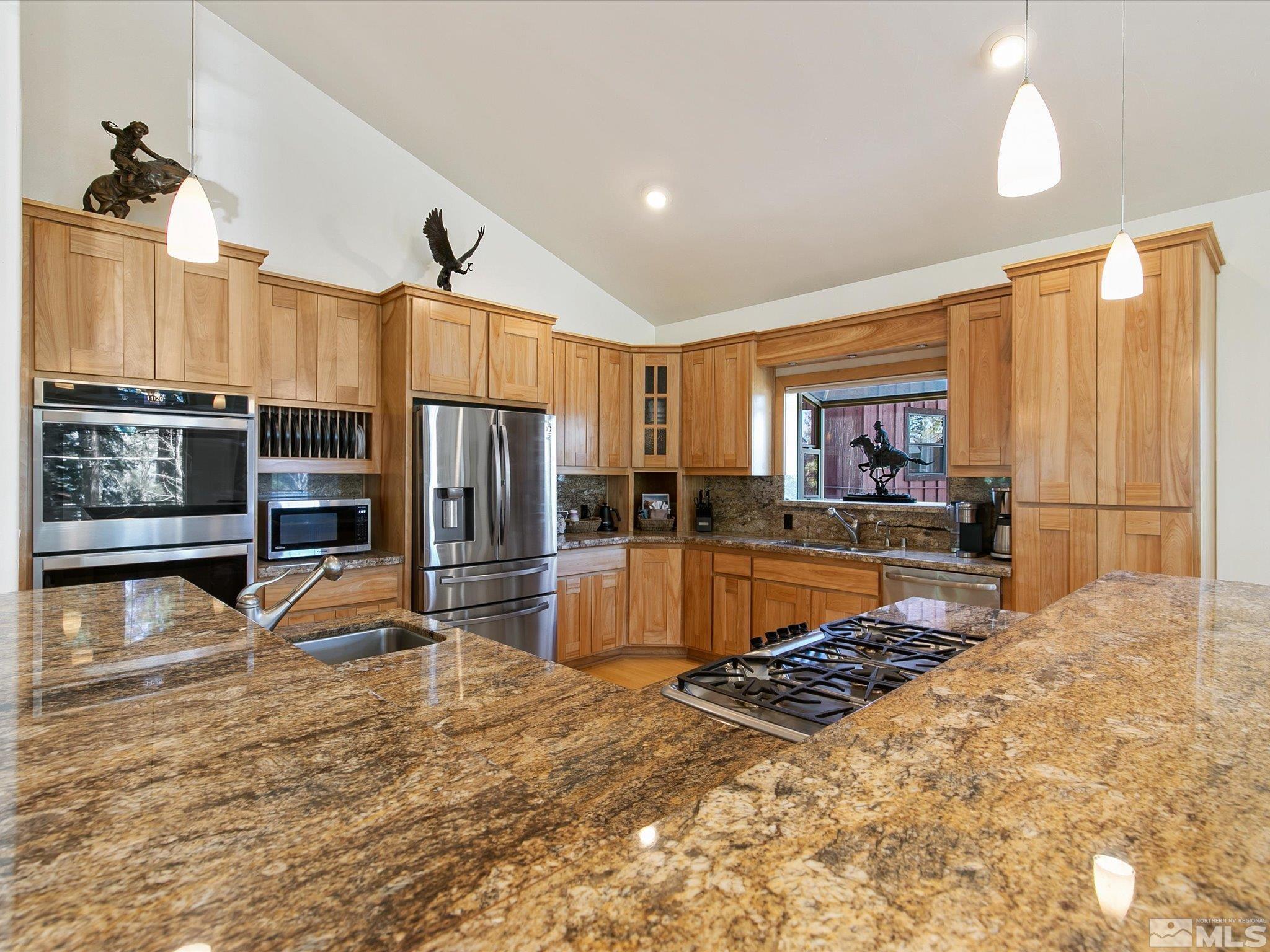 a large kitchen with kitchen island granite countertop a large counter top stainless steel appliances and cabinets