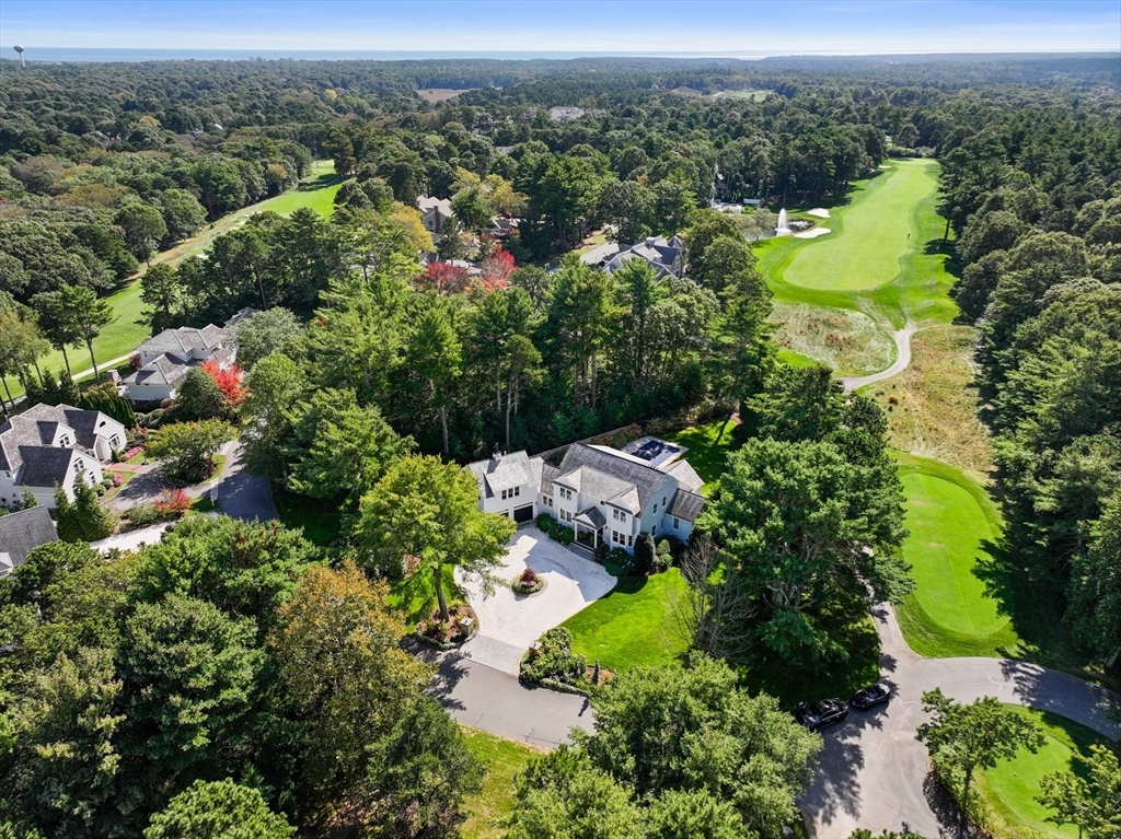 an aerial view of a houses with a yard and lake view