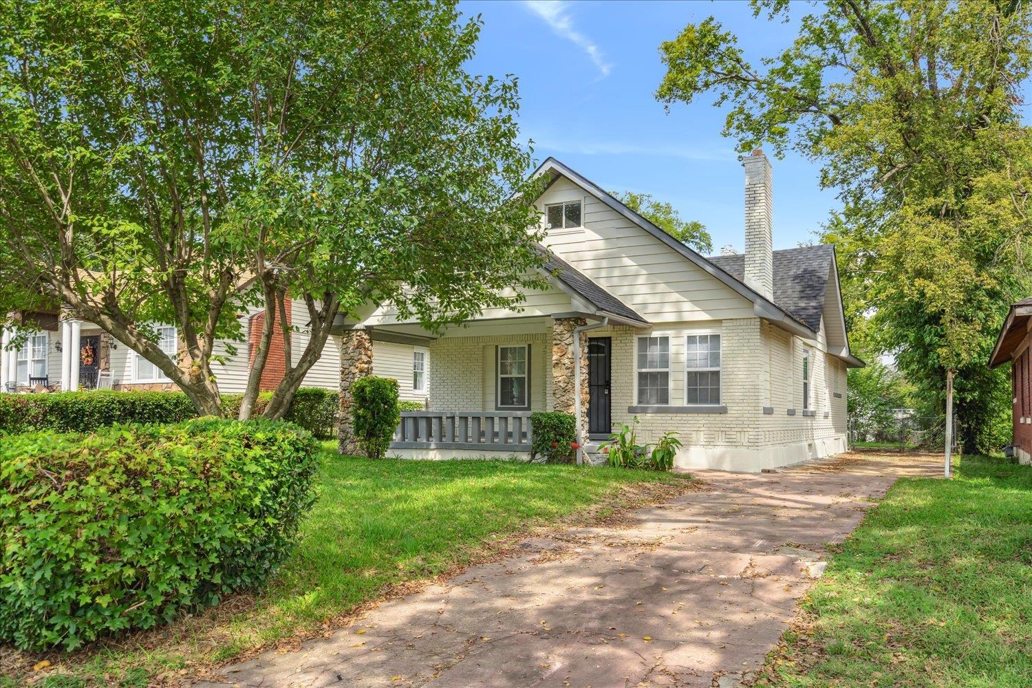 a view of a house with a yard and potted plants