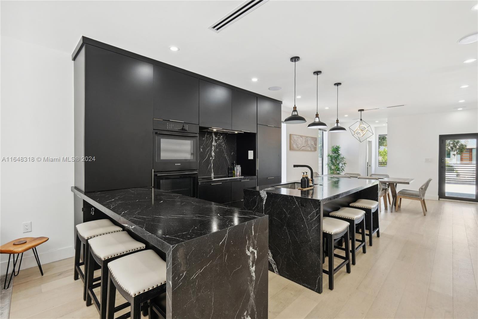 a kitchen with granite countertop a table and chairs in it