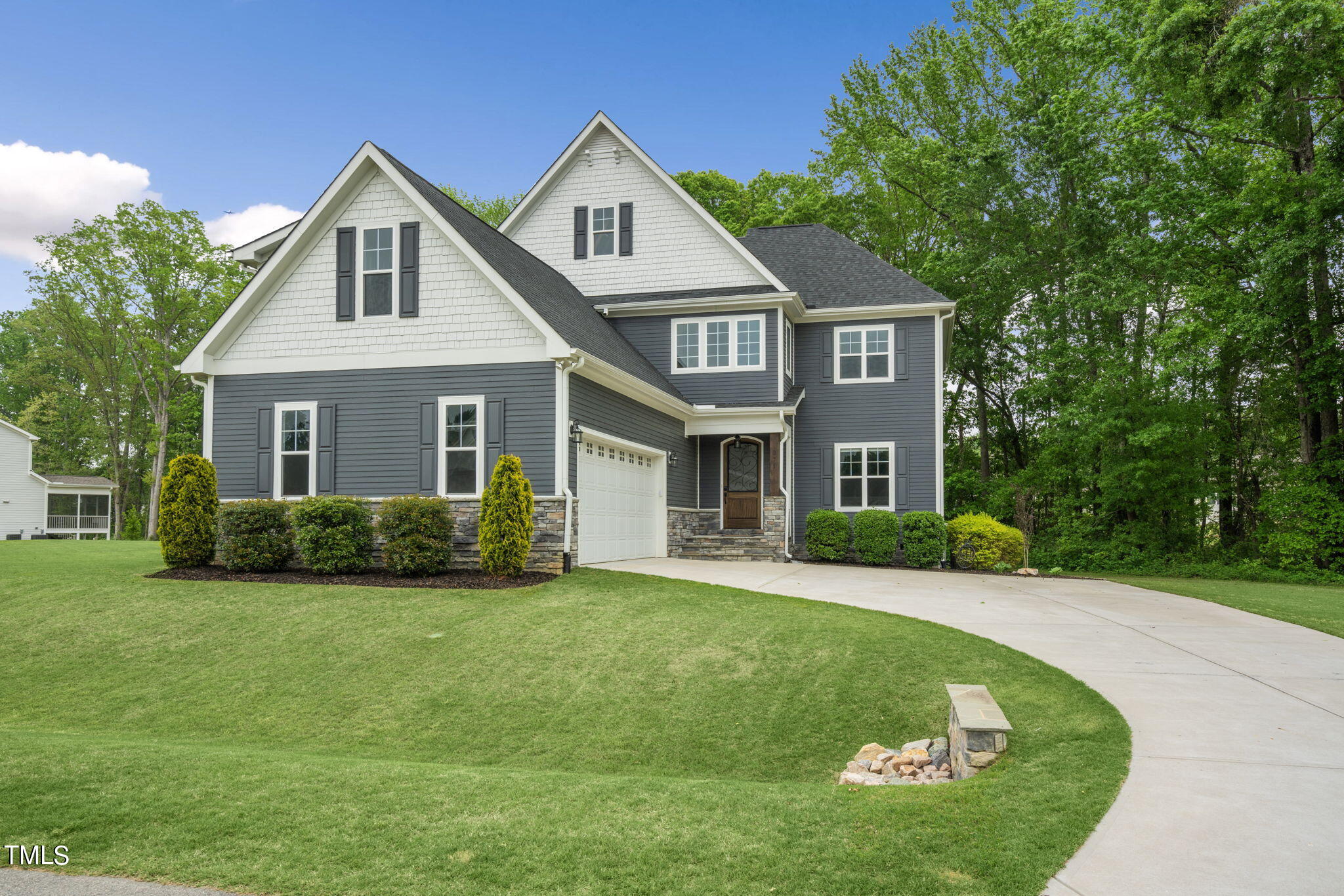 a front view of a house with a garden and yard