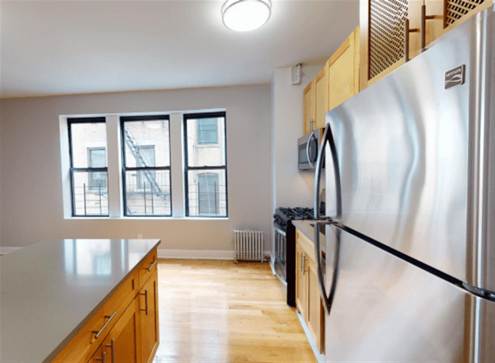 a view of a kitchen with a sink and refrigerator