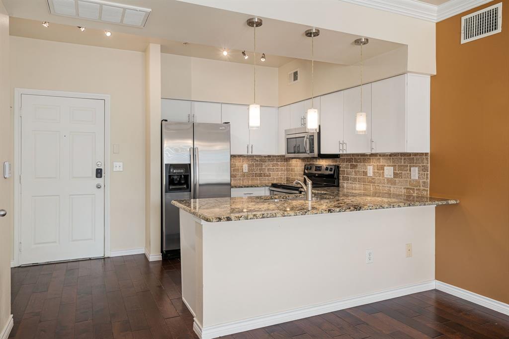 a kitchen with stainless steel appliances granite countertop a sink and a refrigerator