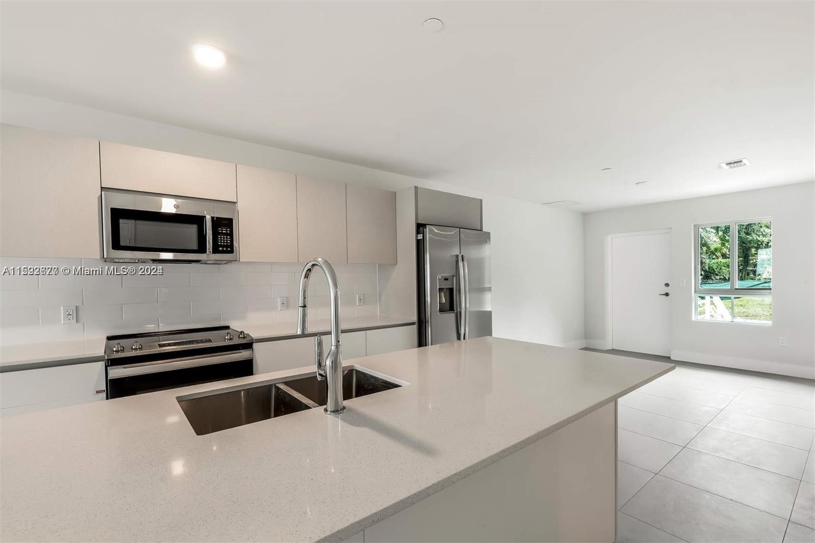 a kitchen with stainless steel appliances a stove a microwave and white cabinets