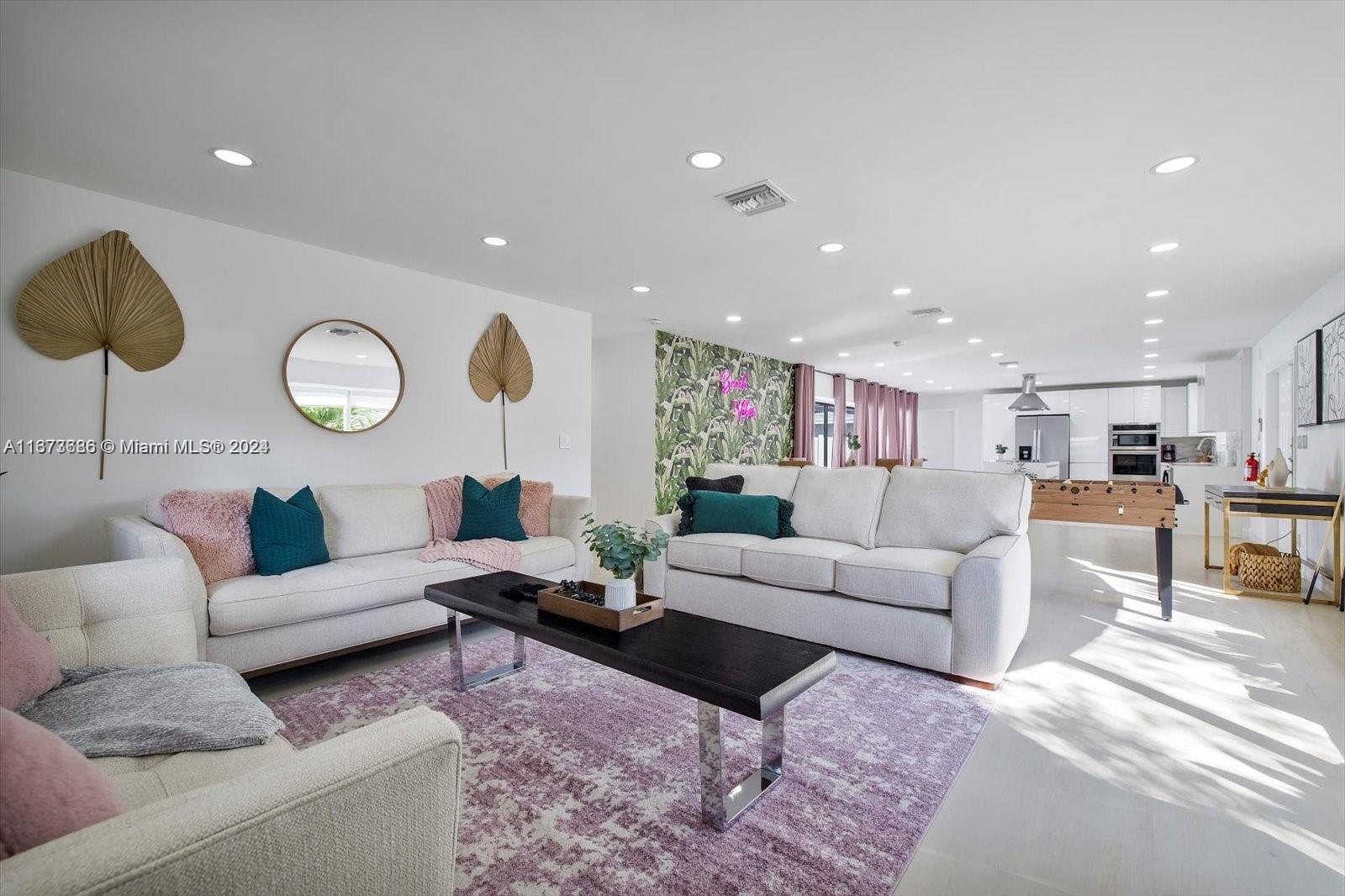 a living room with furniture and kitchen view