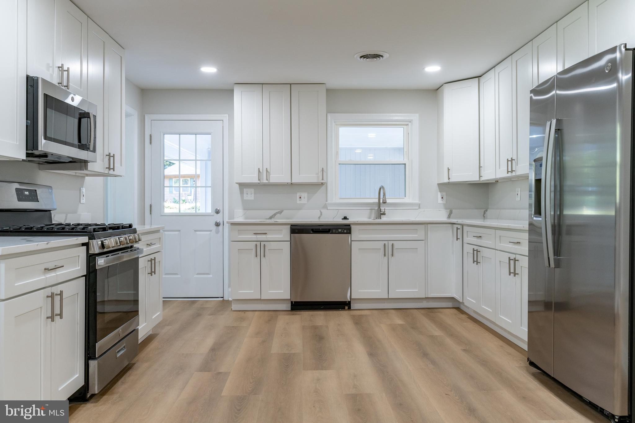 a kitchen with a sink stainless steel appliances and cabinets