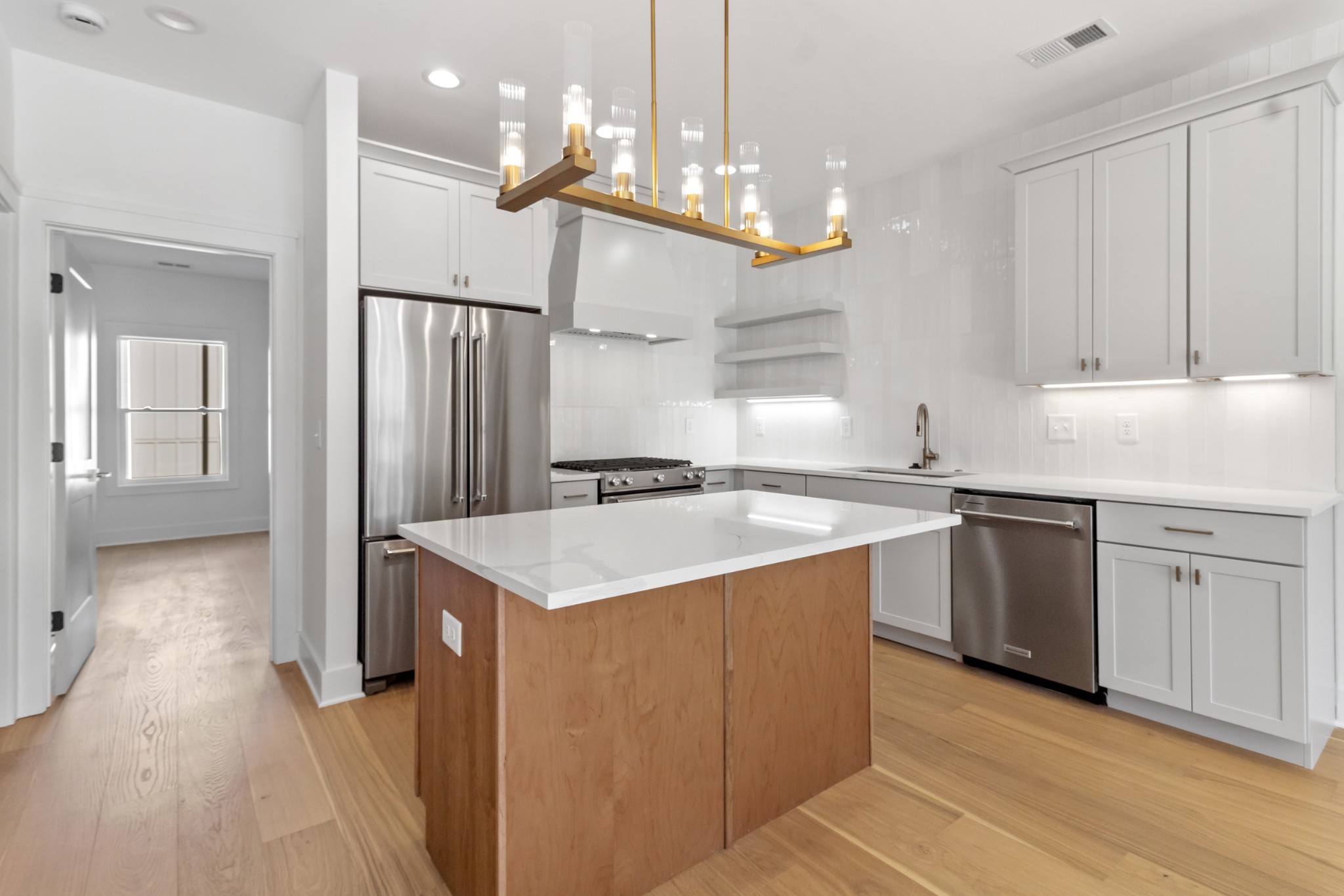 a kitchen with a sink a counter top space stainless steel appliances and cabinets