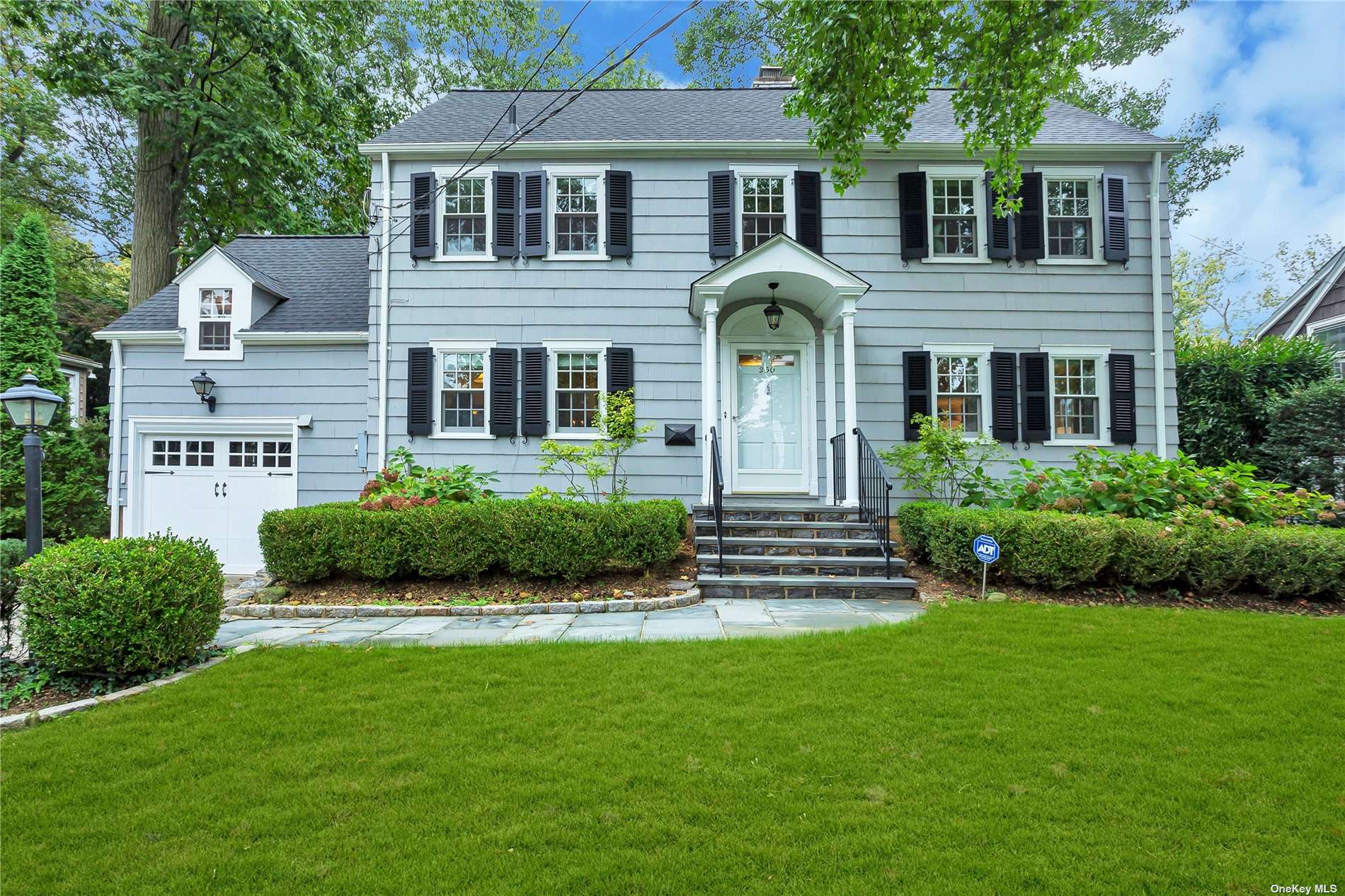 a front view of a house with a garden