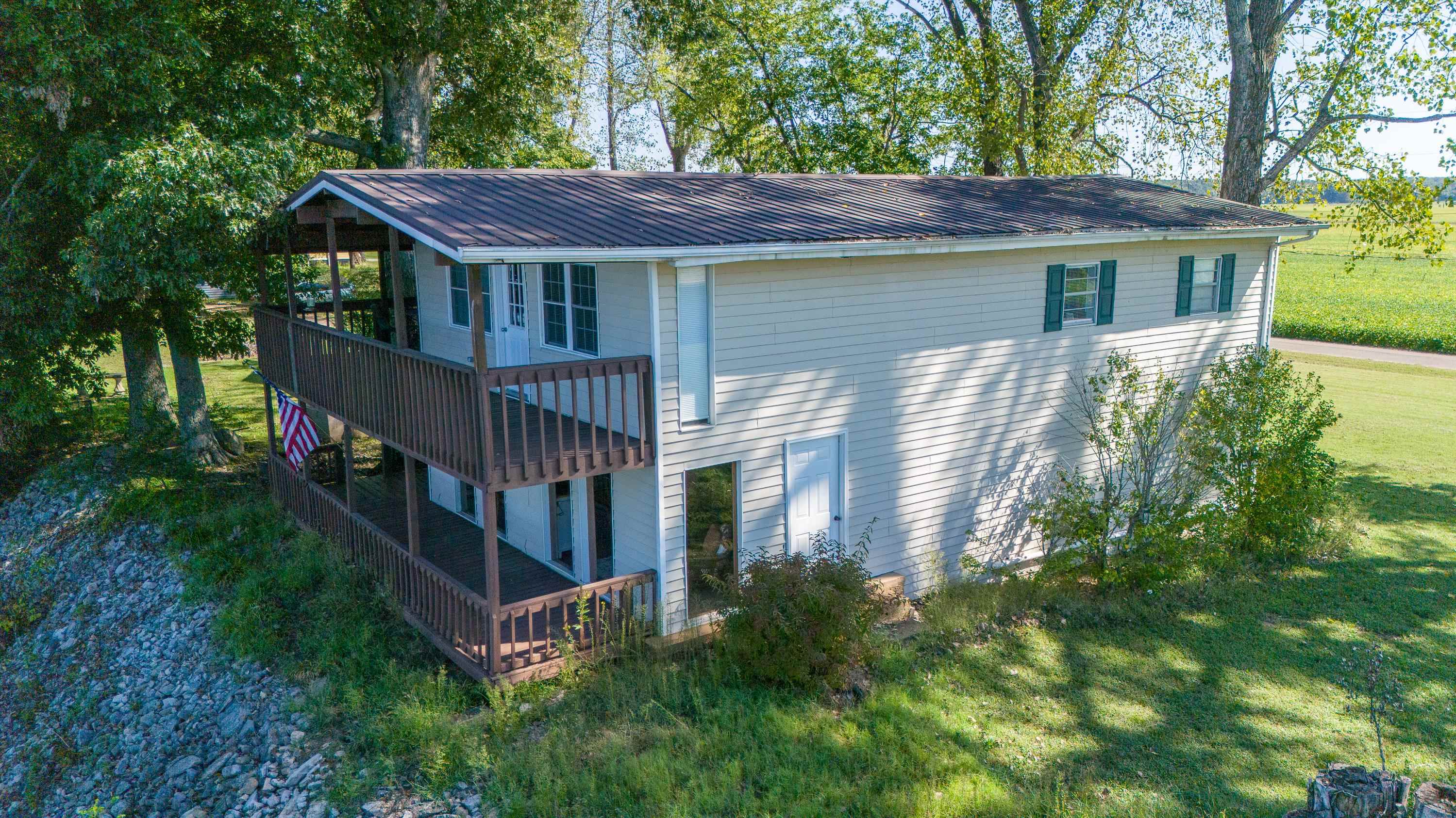 a view of house with roof deck and wooden fence