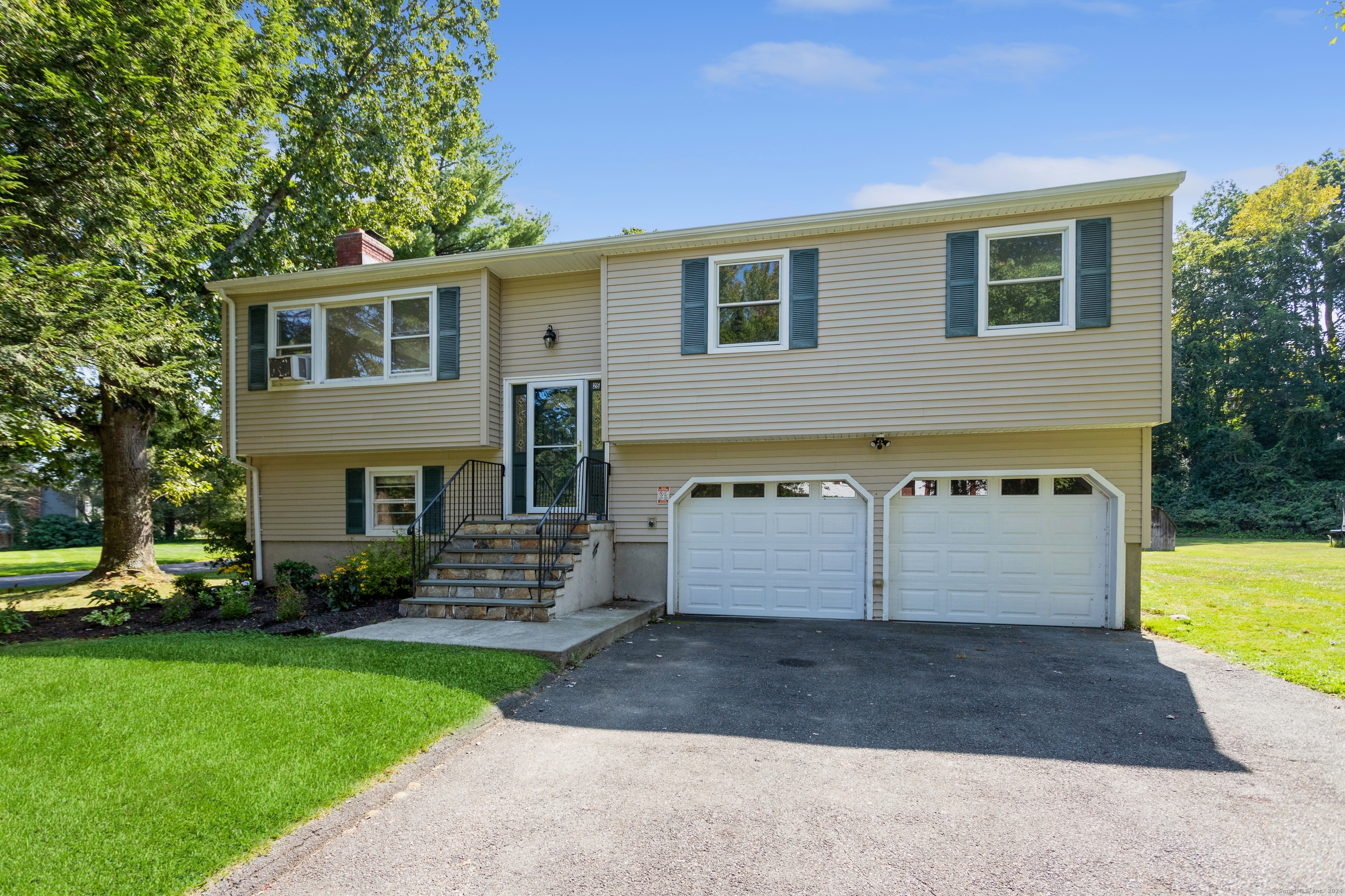 a front view of a house with a yard and trees