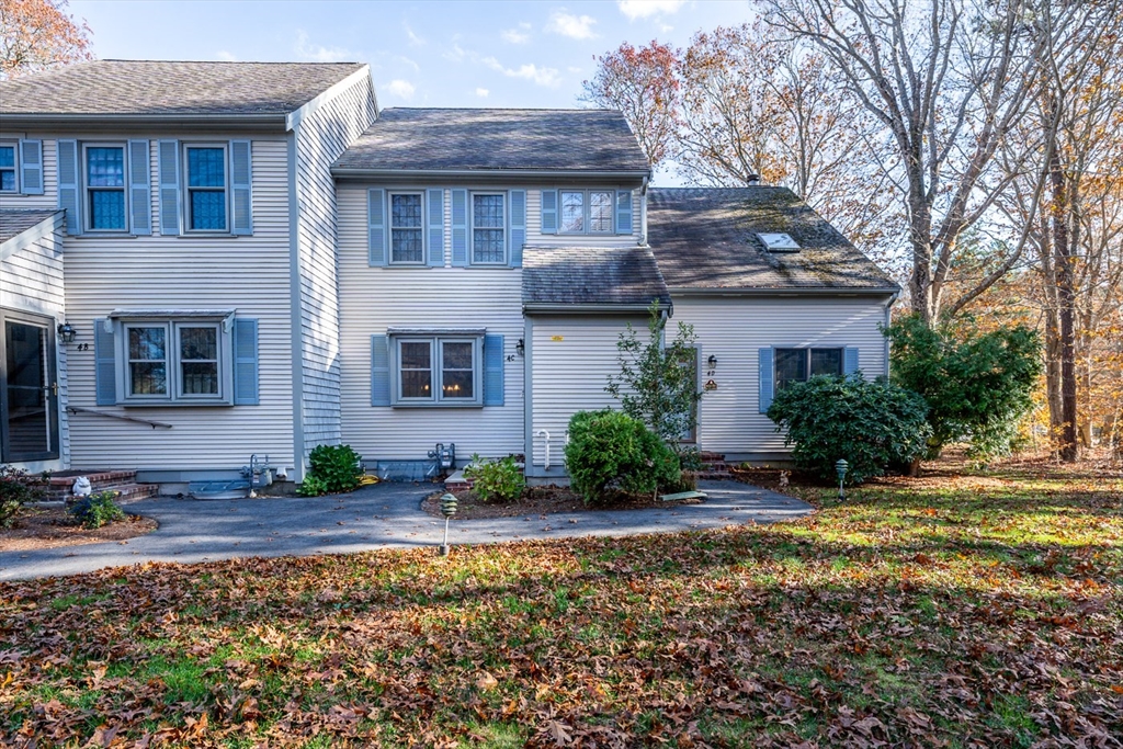 a view of a house with a yard and potted plants