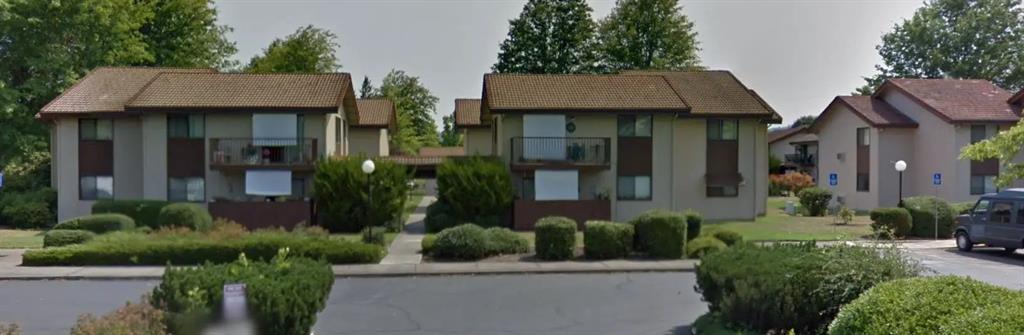 a view of multiple houses with a yard and plants