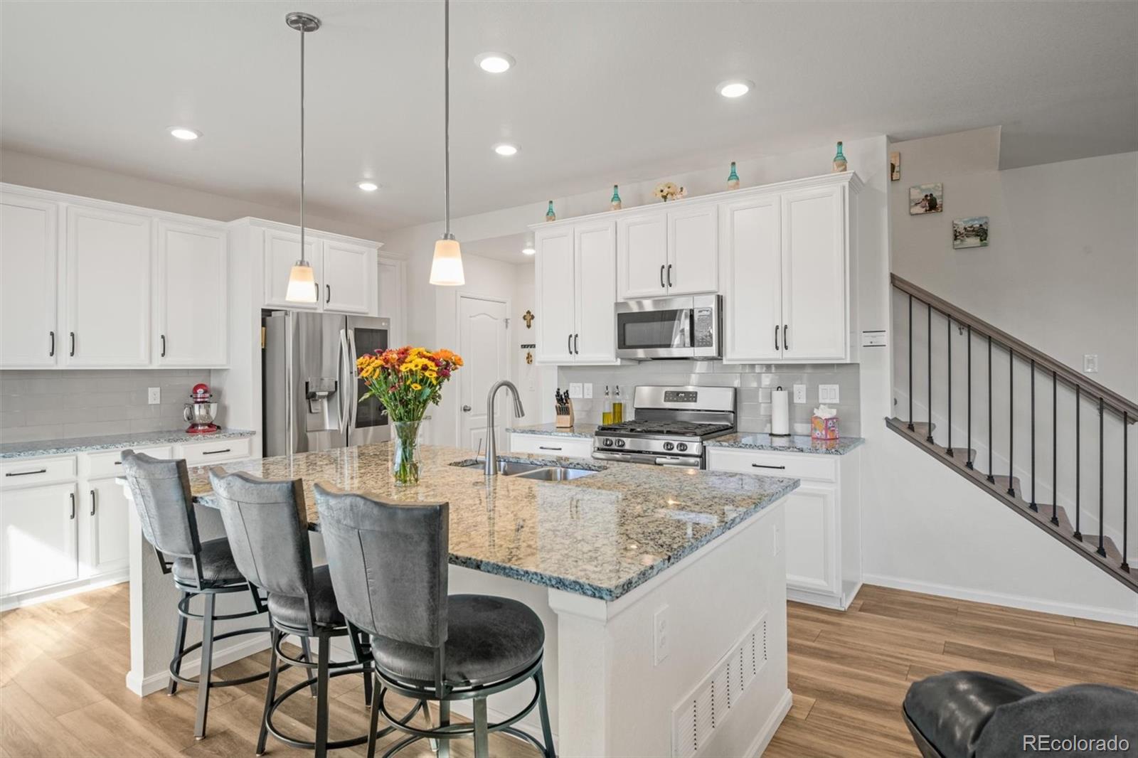 a kitchen with kitchen island granite countertop a table chairs microwave and cabinets