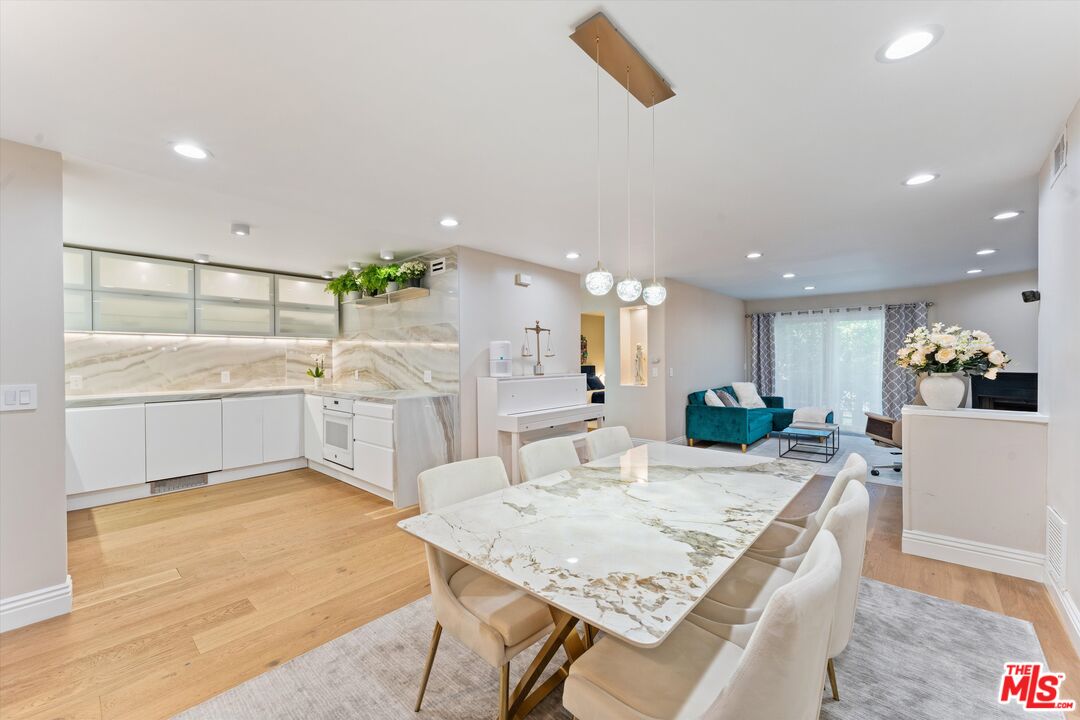 a view of kitchen with kitchen island a sink table and chairs