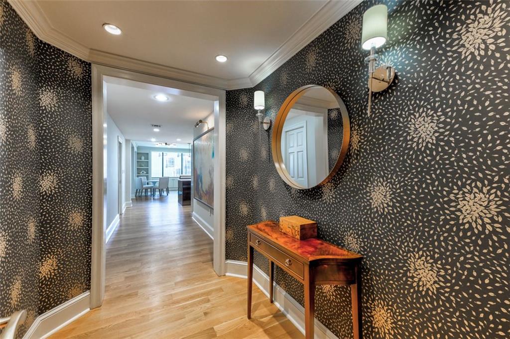 a living room with a mirror and a wooden floor