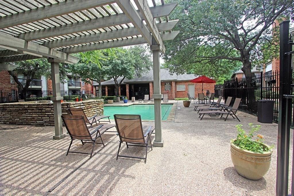 a view of a patio with a dining table and chairs under an umbrella with a patio