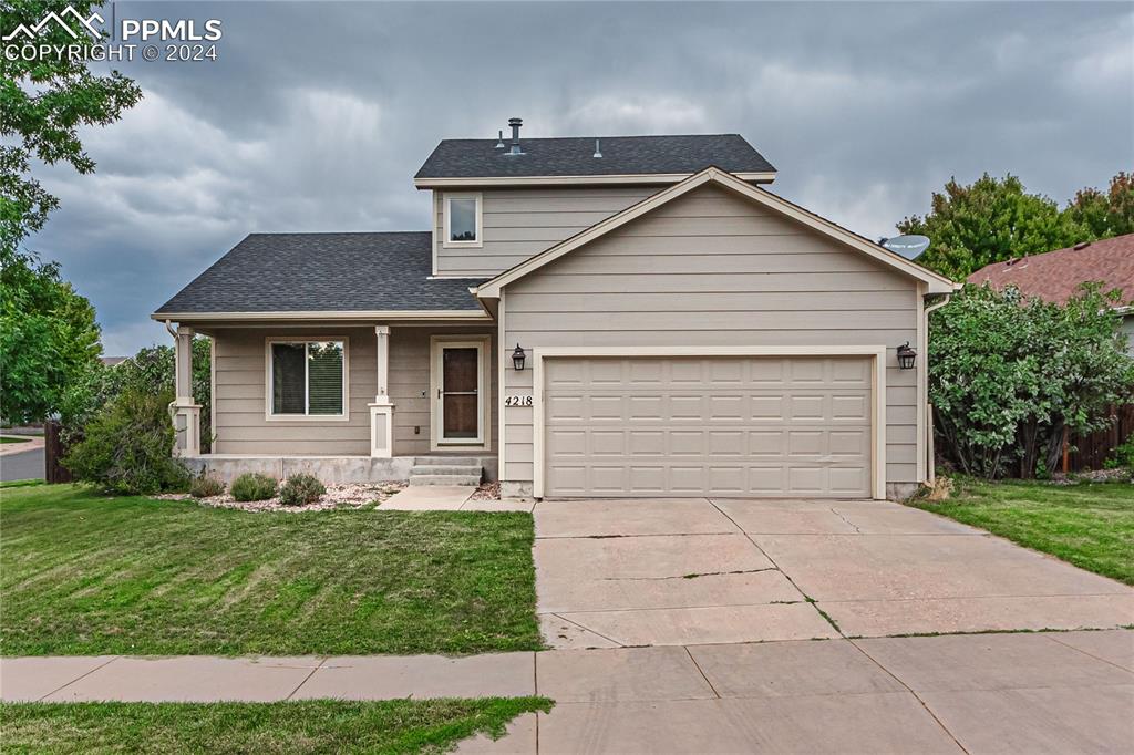 View of front of house with a garage and a front yard