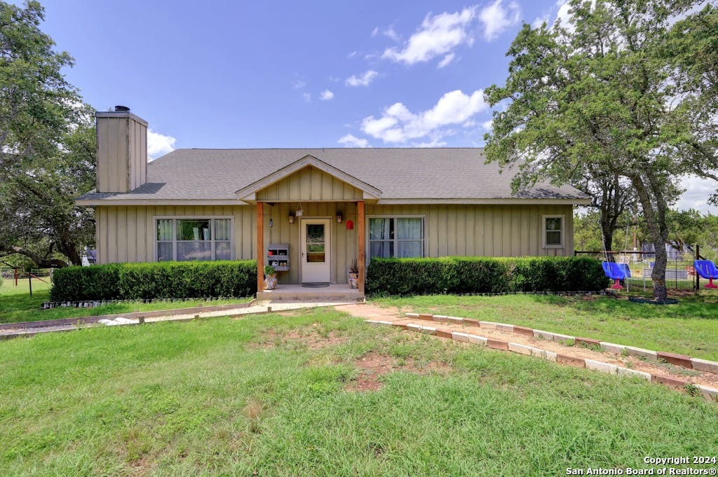 a front view of a house with a yard and trees